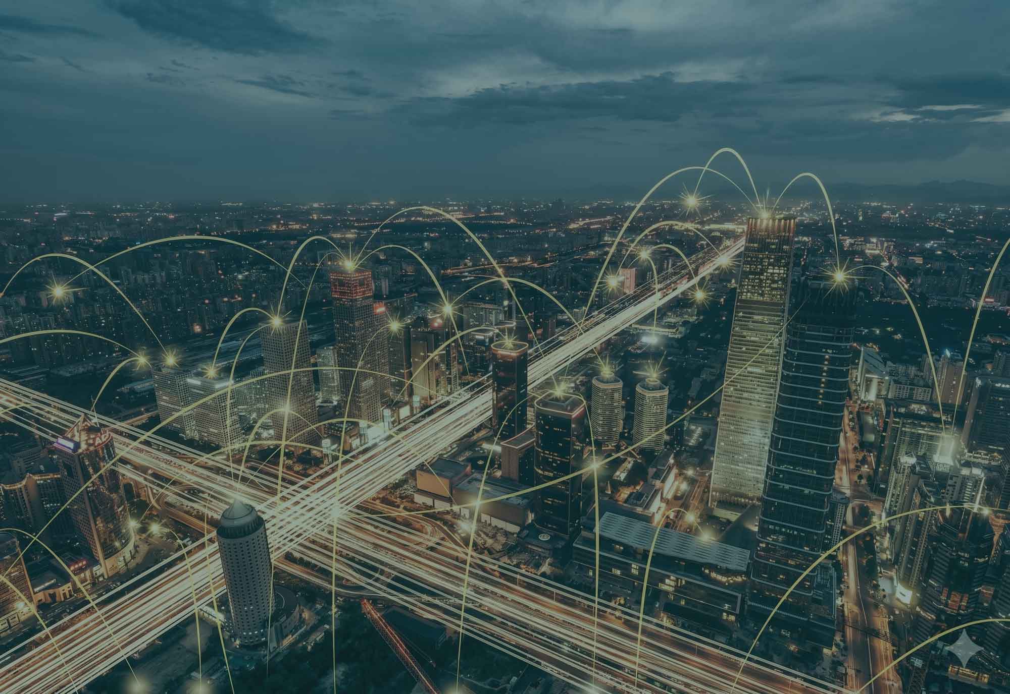 Skyline di una città di notte con linee di connessione digitale sovrapposte, a rappresentare una rete urbana intelligente